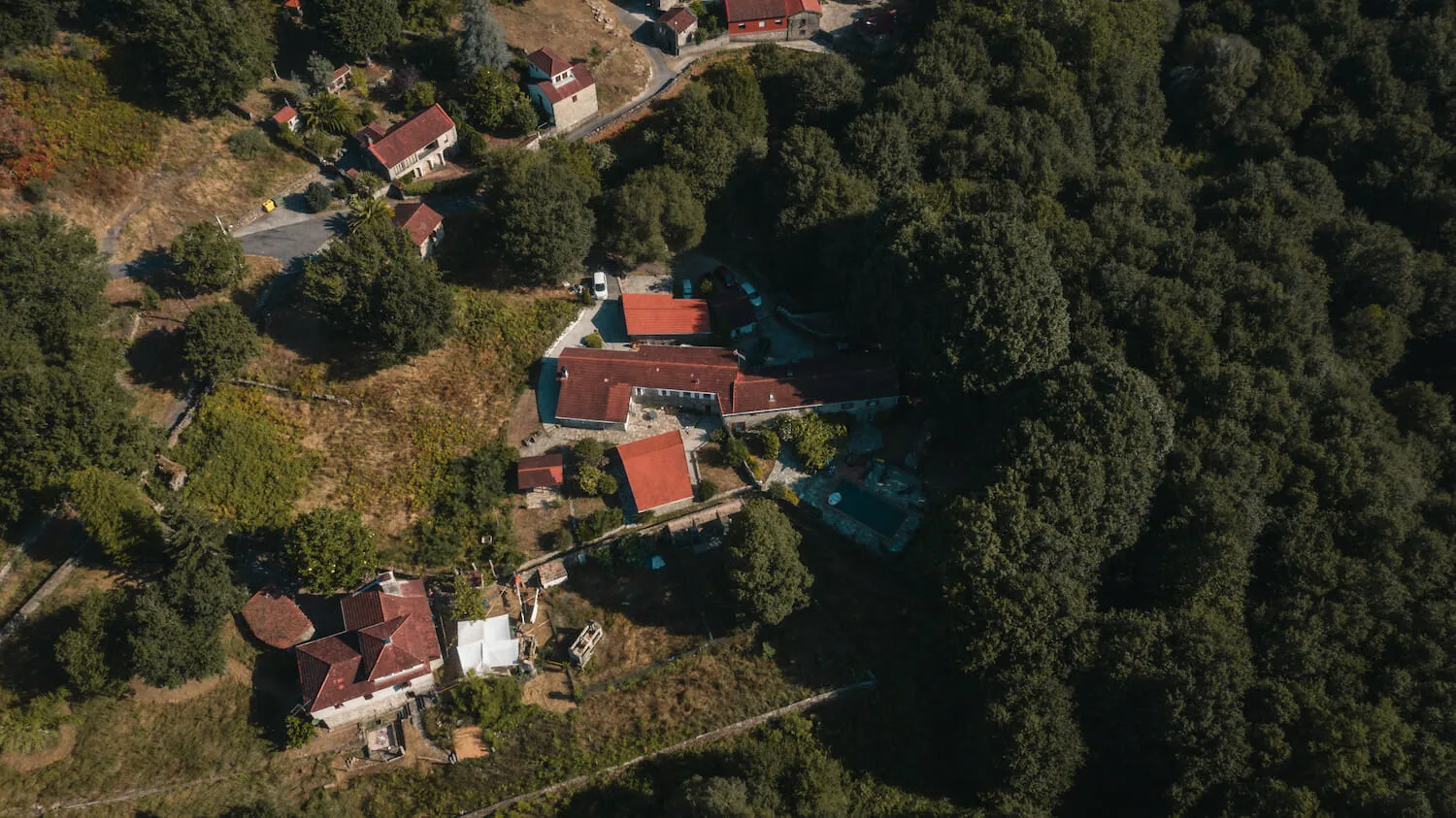 Aerial view of Anceu Coliving on its wooded hillside above the river